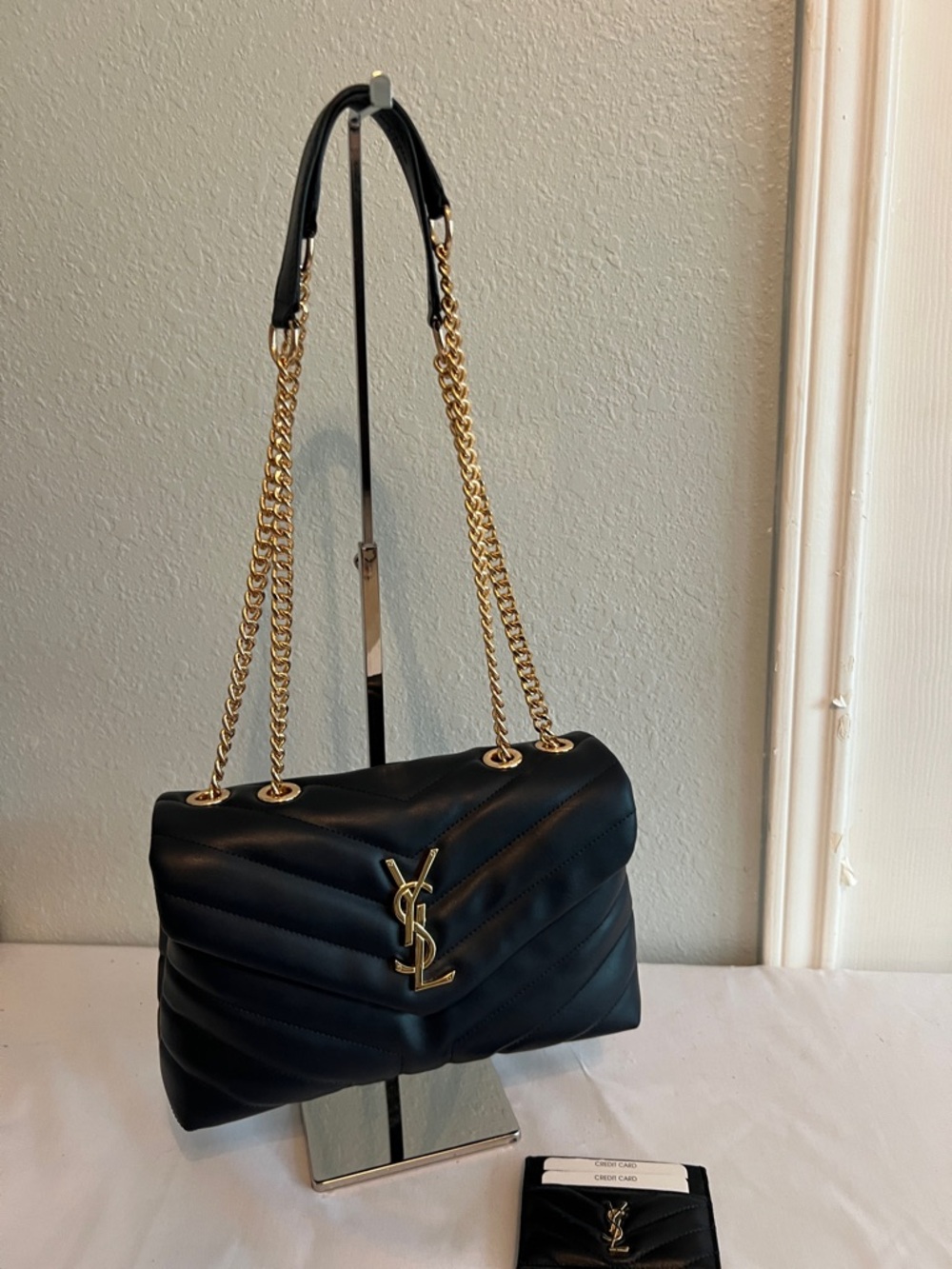 Yves Saint Laurent Navy Blue with gold tone chain and emblem.